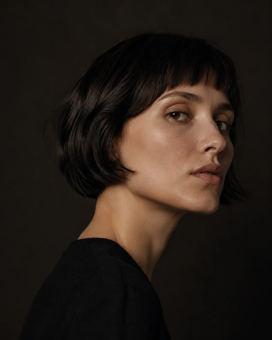 Concept imagery: a sculptural dark bob photographed in warm directional light.